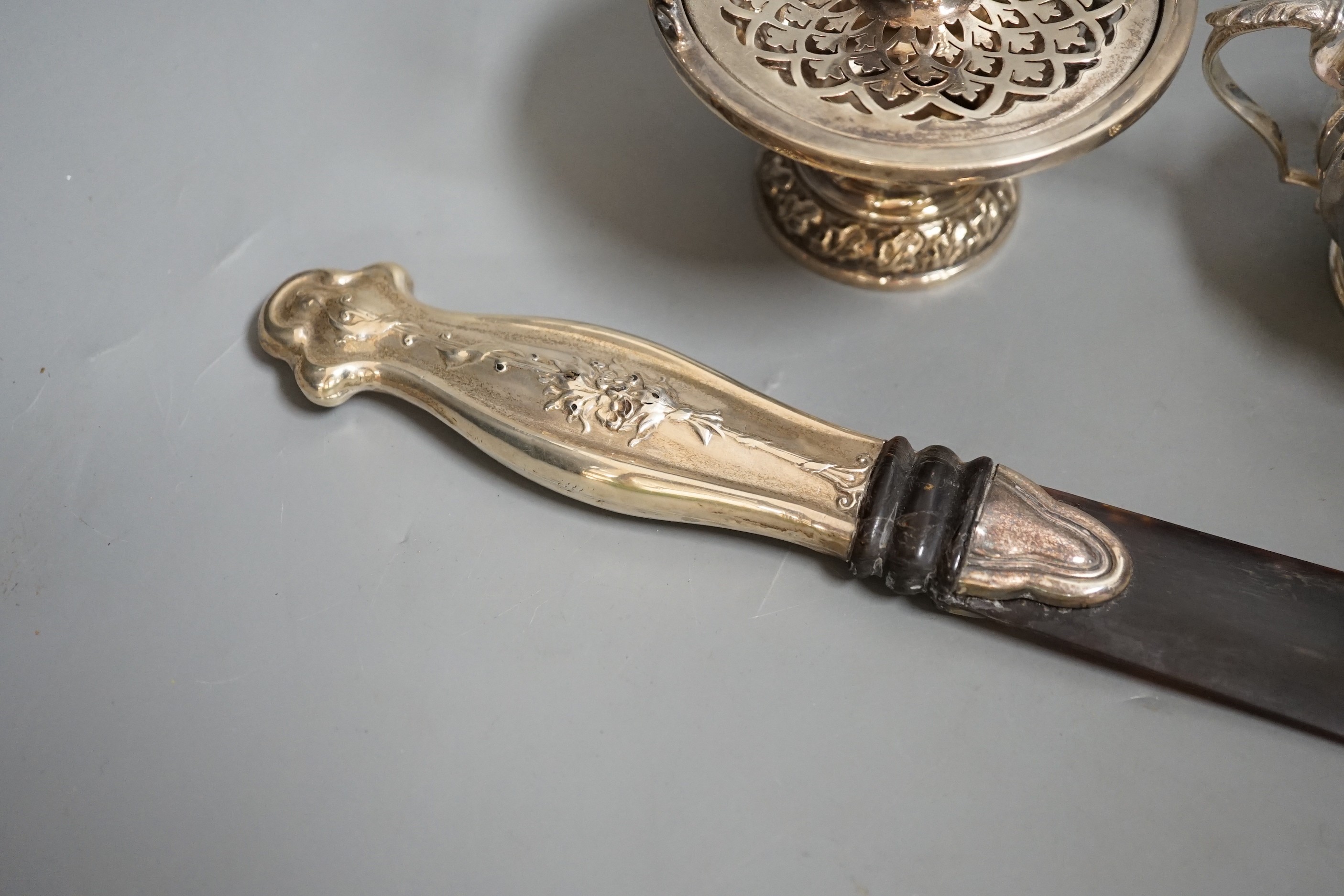 A white metal handled tortoiseshell paper knife and sundry small silver items, including an Edwardian pot pourri basket and two silver condiments by Elkington & Co.